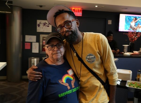 A young man with his arm around an older woman. 