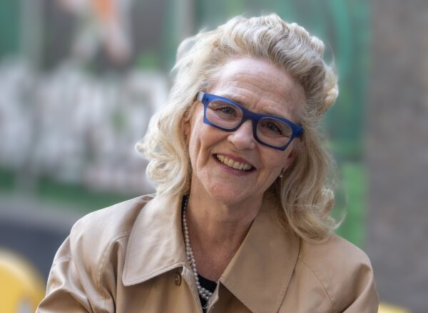 A woman with glasses smiles at the camera. 