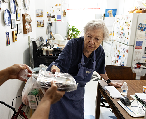 Citymeals on Wheels recipient Joyce, a senior white woman with white hair, receives meals on wheels in New York City. 