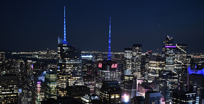 The New York City skyline lit up in Citymeals blue.